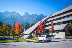 克拉尼斯卡戈拉Špik Alpine Resort的停在大楼前停车场的汽车