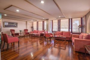 伊古迈尼察乔利酒店 的一间设有红色椅子和沙发的等候室