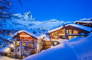 布勒伊-切尔维尼亚圣胡贝图斯度假酒店的山间雪中的房子
