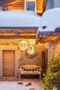布勒伊-切尔维尼亚圣胡贝图斯度假酒店的雪中建筑物边的长凳