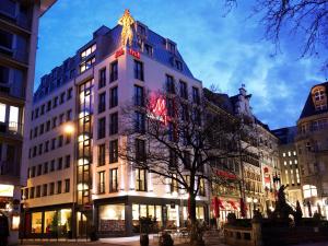 科隆多姆弗瑞赫伊登酒店的夜幕降临的城市街道上一座高大的白色建筑