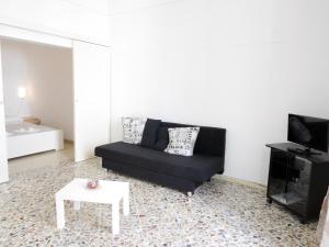 滨海波利尼亚诺La Conchiglia Domus的客厅配有黑色沙发和桌子