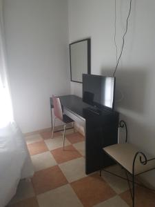 Carboneras de GuadazaónHostal Cabañas的一间卧室配有一张桌子、一台电视和一把椅子