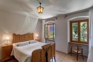 德罗Agriturismo Maso Lizzone的一间卧室配有一张床、两把椅子和窗户