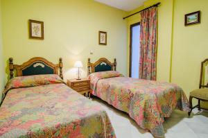 格拉纳达省阿拉马萨尔梅洛内斯公寓的一间卧室设有两张床和窗户。