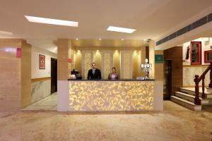 新德里Hotel International Inn - Near Delhi Airport的两个人站在大厅的柜台上