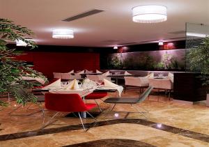 安卡拉德莫拉酒店的一间设有白色桌椅的餐厅,种植了植物