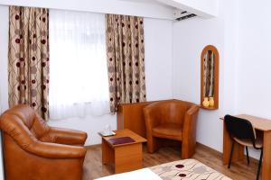 图尔恰精选酒店的客房设有一张床、一张桌子和一把椅子。