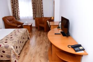 图尔恰精选酒店的酒店的客房,配有一张书桌和一部电话