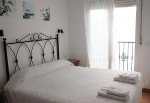 内尔哈内尔哈简约公寓的卧室配有白色的床和2条毛巾