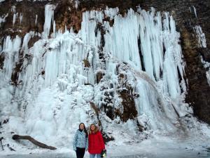 WisłoczekRodzinny Domek Apartament的两个妇女站在冰冻瀑布前