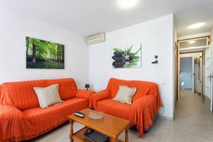 罗列特海岸Maison Lamic 2的客厅配有2张橙色沙发和1张桌子