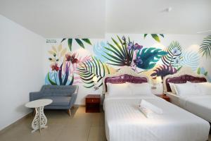 梳邦再也USJ-21艺术酒店的一间卧室配有两张床、一张沙发和一个壁画
