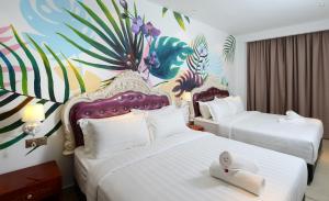梳邦再也USJ-21艺术酒店的两张位于酒店客房的床铺,配有壁画