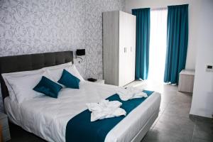 马尔萨什洛克渔夫的小海湾住宿加早餐旅馆的一间卧室配有一张带蓝色和白色毛巾的床