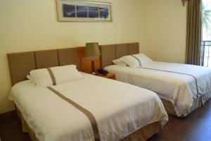 塞班塞班海滩酒店的酒店客房,配有两张带白色床单的床