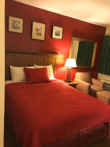 蒙蒂塞洛峡谷汽车旅馆的红色卧室配有床和椅子