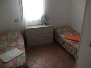玛里纳罗米亚Appartamento La Valle的一间卧室设有两张床、一个梳妆台和窗户。