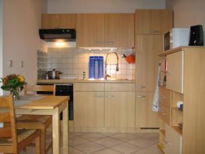 迪尔门Kleine Wohnung mit Terrasse的厨房配有木制橱柜、餐桌和用餐室