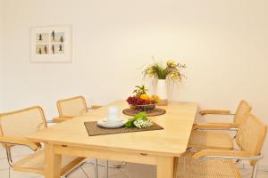 岑平Residenz Waldhaus_05的一张带椅子的木桌和一碗水果