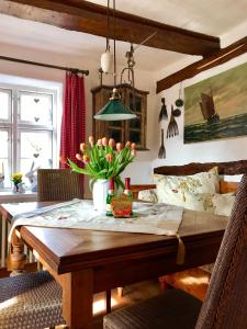 普雷罗Haus am Hafen - romantisch unter Reet, Garten mit Strandkorb und Terrasse的用餐室配有带鲜花的木桌