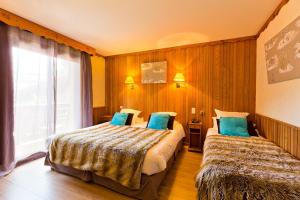 拉克吕萨Les Airelles的酒店客房设有两张床和窗户。