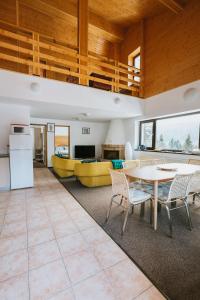 锡纳亚Panoramic Apartments - MontePalazzo Sinaia的厨房以及带桌椅的起居室。