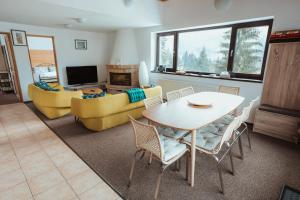 锡纳亚Panoramic Apartments - MontePalazzo Sinaia的客厅配有桌子和沙发