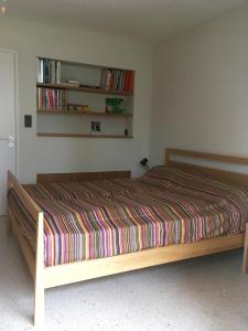 滨海萨纳里Villa Magali的一间卧室配有带条纹被子的床