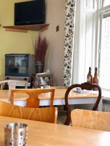 耶夫勒铁路酒店的一间带桌椅和电视的用餐室