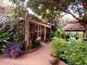 博博迪乌拉Villa Bobo的门廊和茅草屋顶的房子