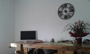 科莫B&B LORI的一张桌子,上面配有电视和墙上的时钟