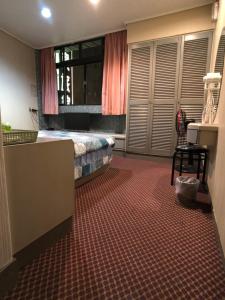 礁溪亚仕登旅馆的一间卧室配有一张床、一张桌子和一把椅子