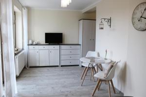 达尔沃沃Gościrada的白色的客房配有桌椅和时钟