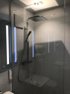 巴特克罗伊茨纳赫Luxus-Appartement im Herzen der Stadt的带淋浴的浴室,浴室设有玻璃淋浴间,位于后门