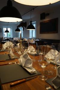 迪森阿姆阿梅尔塞Mara Restaurant & Hotel的一张长木桌,上面有眼镜和餐巾