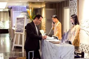 日惹Platinum Adisucipto Hotel & Conference Center的两个男人和一个女人站在商店的桌子上