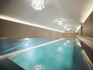维也纳维也纳无忧宫酒店的一个带大型蓝色游泳池的游泳池