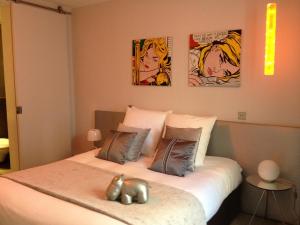巴黎拉迈松德利亚酒店的卧室配有一张墙上三幅画作的床