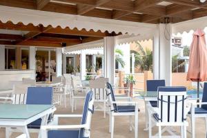 达喀尔爱可酒店的庭院配有白色的桌椅和遮阳伞。