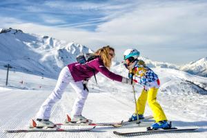 圣费朗索瓦-隆尚Résidence Goélia - Le Rond Point des Pistes的雪上滑雪的女人和孩子