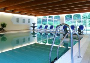 拉尔斯维克拉尔斯维克城堡酒店的一个带椅子的游泳池以及一个室内游泳池