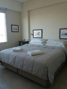 萨尔塔Departamento moderno centrico, vista ciudad, valle y montañas的一间卧室配有一张大床和毛巾