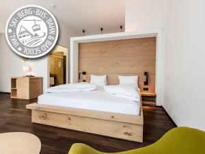 施库尔贝尔维德施库尔酒店的一间卧室配有一张大床和木制床头板