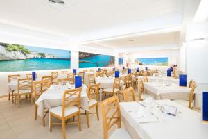 卡拉恩·布拉內斯Globales Almirante Farragut的一间设有白色桌椅的海洋餐厅