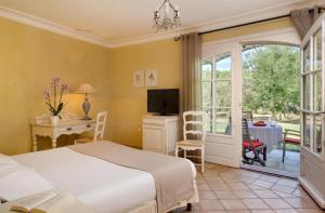艾格-莫尔特玛斯德塞博斯酒店的一间卧室配有一张床、一张书桌和一台电视