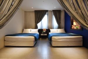 马六甲马六甲里奥后院公寓的配有两张床铺的蓝色墙壁和窗户