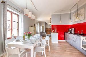 柏林Idyllisches Haus mitten in Berlin的厨房配有红色墙壁,配有白色的桌椅