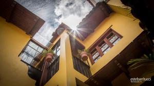 塔帕尔帕Hotel Posada Real Tapalpa的天上有窗户和太阳的黄色建筑