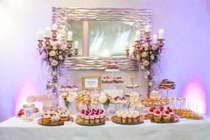 希隆斯克地区佩卡雷帝权酒店的一张桌子,上面有蛋糕和糕点,还有镜子